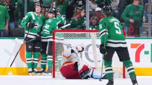 Calgary Flames goaltender Devin Cooley, centre, is slow to get up as Dallas Stars players celebrate a second-period goal by Justin Hryckowian during an NHL hockey game Tuesday, April 7, 2026, in Dallas. (Julio Cortez/AP)