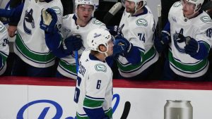 Vancouver Canucks right wing Brock Boeser, front, is congratulated as he passes the team box after scoring his third goal of the contest in the third period of an NHL hockey game against the Colorado Avalanche Wednesday, April 1, 2026, in Denver. (David Zalubowski/AP)
