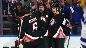 Buffalo Sabres right wing Alex Tuch, center, celebrates after his goal with defenseman Luke Schenn (5) and center Ryan McLeod (71) during the first period of an NHL hockey game against the Tampa Bay Lightning, Monday, April 6, 2026, in Buffalo, N.Y. (Jeffrey T. Barnes/AP)