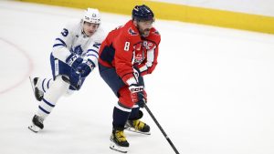 Washington Capitals left wing Alex Ovechkin (8) skates with the puck past Toronto Maple Leafs left wing Matthew Knies (23) during the third period of an NHL hockey game, Wednesday, Nov. 13, 2024, in Washington. The Maple Leafs won 4-3 in overtime. (AP Photo/Nick Wass)
