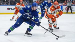 Vancouver Canucks' Drew O'Connor (18) skates with the puck while being watched by Anaheim Ducks' Ian Moore (74) during the third period of an NHL hockey game, in Vancouver, on Thursday, January 29, 2026. THE CANADIAN PRESS/Darryl Dyck