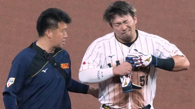Japan's Seiya Suzuki is helped off the field after being injured at second base at the with the first inning during a World Baseball Classic quarterfinal game against Venezuela, Saturday, March 14, 2026, in Miami. (Marta Lavandier/AP)