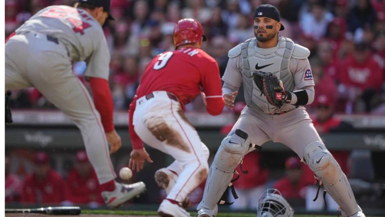 Boston Red Sox catcher Carlos Narváez, right, looks on as Cincinnati Reds' Matt McLain, center, scores as Boston Red Sox pitcher Sonny Gray, left, fields the ball in the first inning of a baseball game in Cincinnati, Saturday, March 28, 2026. (Carolyn Kaster/AP)