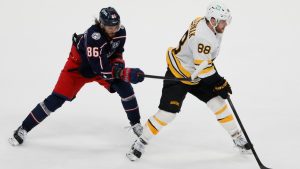 Boston Bruins' David Pastrnak, right, carries the puck into the offfensive zone as Columbus Blue Jackets' Kirill Marchenko defends during the overtime period of an NHL hockey game, Sunday, March 29, 2026, in Columbus, Ohio. (AP Photo/Jay LaPrete)