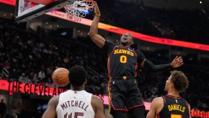 Atlanta Hawks forward Jonathan Kuminga (0) dunks in front of Cleveland Cavaliers guard Donovan Mitchell (45) and teammate Dyson Daniels (5) in the second half of an NBA basketball game in Cleveland, Wednesday, April 8, 2026. (Sue Ogrocki/AP)
