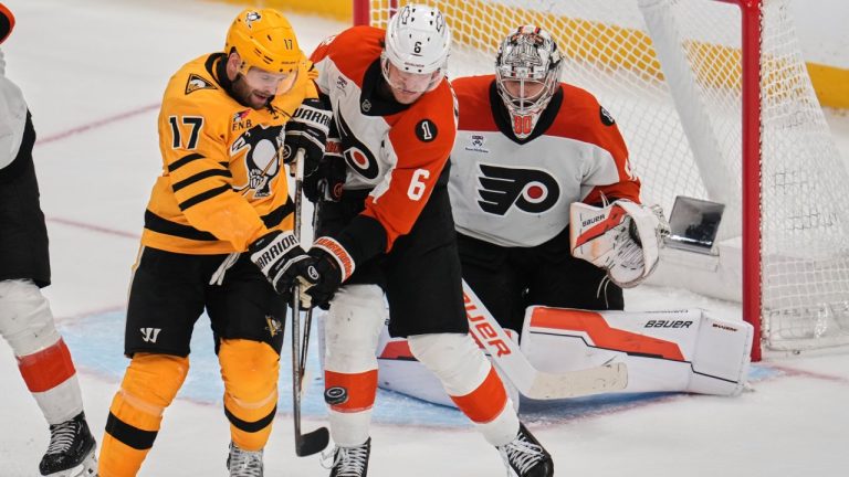 Pittsburgh Penguins' Bryan Rust (17) cannot get his stick on the puck while defended by Philadelphia Flyers' Travis Sanheim (6) in front of Flyers goaltender Dan Vladar, right, during the third period of Game 2 in the first round of the NHL Stanley Cup playoffs in Pittsburgh, Monday, April 20, 2026. (AP Photo/Gene J. Puskar)
