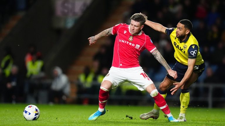 Wrexham's Josh Windass, left, and Oxford United's Brodie Spencer battle for the ball during the EFL Championship soccer match between Oxford United and Wrexham, Tuesday, April 28, 2026, in Oxford, England. (David Davies/PA via AP)