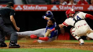 Toronto Blue Jays' Vladimir Guerrero Jr. slides into home plate as Los Angeles Angels catcher Logan O'Hoppe (14) attempts to tag him out after Blue Jays' Lenyn Sosa doubled to right field, driving in Guerrero and Ernie Clement during the eighth inning of a baseball game Tuesday, April 21, 2026, in Anaheim, Calif. (Caroline Brehman/AP)