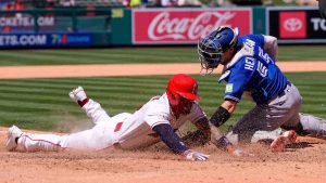 Los Angeles Angels' Yoan Moncada, left, scores under the age of Toronto Blue Jays catcher Tyler Heineman on a double by Nolan Schanuel during the seventh inning of a baseball game Wednesday, April 22, 2026, in Anaheim, Calif. (Mark J. Terrill/AP)