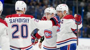 Montreal Canadiens defenceman Lane Hutson, centre, celebrates his goal against the Tampa Bay Lightning with left wing Juraj Slafkovsky, left, and centre Nick Suzuki, right, during the first period in Game 2 of an NHL hockey Stanley Cup first-round playoff series, Tuesday, April 21, 2026, in Tampa, Fla. (Chris O'Meara/AP)