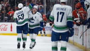 Vancouver Canucks right wing Brock Boeser, centre, celebrates his goal with centre Teddy Blueger, left, during the third period of an NHL hockey game against the Anaheim Ducks, Sunday, April 12, 2026, in Anaheim, Calif. (Kyusung Gong/AP)