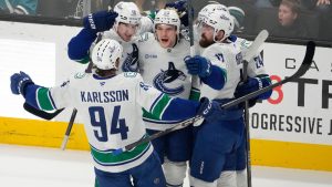 Vancouver Canucks centre Teddy Blueger, centre, celebrates with teammates after scoring a goal during the third period of an NHL hockey game against the San Jose Sharks in San Jose, Calif., Saturday, April 11, 2026. (Tony Avelar/AP)