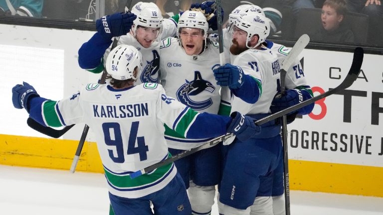 Vancouver Canucks centre Teddy Blueger, centre, celebrates with teammates after scoring a goal during the third period of an NHL hockey game against the San Jose Sharks in San Jose, Calif., Saturday, April 11, 2026. (Tony Avelar/AP)