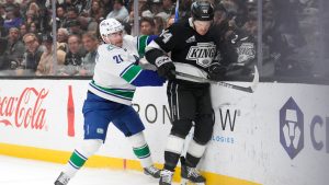 Vancouver Canucks left wing Nils Hoglander, left, and Los Angeles Kings defenseman Mikey Anderson battle for the puck during the first period of an NHL hockey game Thursday, April 9, 2026, in Los Angeles. (Mark J. Terrill/AP)