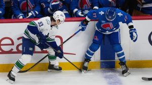 Vancouver Canucks centre Teddy Blueger, left, fights for control of the puck with Colorado Avalanche center Parker Kelly in the first period of an NHL hockey game Wednesday, April 1, 2026, in Denver. (David Zalubowski/AP)
