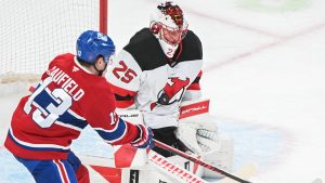 Montreal Canadiens' Cole Caufield (13) moves in on New Jersey Devils goaltender Jacob Markstrom (25) during first period NHL hockey action in Montreal, Sunday, April 5, 2026. (Graham Hughes/CP)