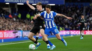 Chelsea's Liam Delap, left, and Brighton and Hove Albion's Olivier Boscagli battle for the ball during the English Premier League soccer match between Brighton & Hove Albion and Chelsea in Brighton, England, Tuesday, April 21, 2026. (Gareth Fuller/PA via AP)