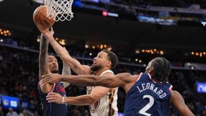 Golden State Warriors guard Stephen Curry (30) goes up for a basket under defense by Los Angeles Clippers forward Kawhi Leonard (2) and forward/center John Collins (20) during the second half of an NBA basketball game Monday, Jan. 5, 2026, in Inglewood, Calif. (Jae C. Hong/AP)