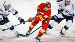 Los Angeles Kings' Mikey Anderson, left, and Scott Laughton, right, check Calgary Flames' Blake Coleman during first period NHL hockey action in Calgary on Thursday, April 16, 2026. (Jeff McIntosh/CP)