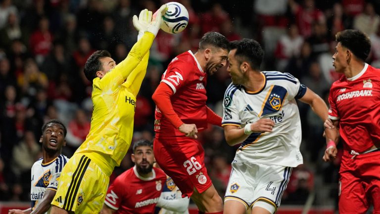JT Marcinkowski goalkeeper of the United States' LA Galaxy, left, dives for the ball past Paulinho of Mexico's Toluca (26) during a CONCACAF Champions Cup quarterfinal first leg soccer match in Toluca, Mexico, Wednesday, April 8, 2026. (Fernando Llano/AP)