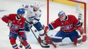 Montreal Canadiens goaltender Jakub Dobes (75) makes a save as Tampa Bay Lightning's Jake Guentzel (59) battles for the rebound against Canadiens' Mike Matheson (8) during first period NHL playoff hockey action in Montreal on Friday, April 24, 2026. (Christinne Muschi/AP)