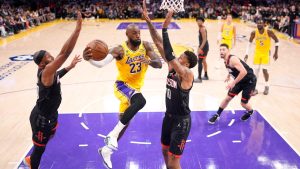 Los Angeles Lakers forward LeBron James, second from left, passes the ball as Houston Rockets guard Josh Okogie, left, and forward Jabari Smith Jr. defend during the first half in Game 1 of a first-round NBA playoffs basketball series Saturday, April 18, 2026, in Los Angeles. (AP Photo/Mark J. Terrill)