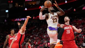 Los Angeles Lakers forward LeBron James (23) goes to the basket against Houston Rockets' Reed Sheppard, left, and Alperen Sengun (28) during the first half in Game 4 of a first-round NBA basketball playoffs series, Sunday, April 26, 2026, in Houston. (Karen Warren/AP)
