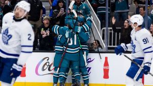 San Jose Sharks centre Zack Ostapchuk, obscured, is congratulated by right wing Adam Gaudette (81) and other players after he scored a goal against the Toronto Maple Leafs during the first period of an NHL hockey game in San Jose, Calif., Thursday, April 2, 2026. (John Hefti/AP)