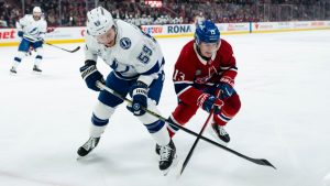 Montreal Canadiens' Cole Caufield (13) and Tampa Bay Lightning' Jake Guentzel (59) vie for possession of the puck during first period NHL action, in Montreal on Thursday, April 9, 2026. (Christopher Katsarov/CP)
