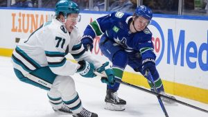 San Jose Sharks' Macklin Celebrini and Vancouver Canucks' Tom Willander vie for the puck during the first period of an NHL game, in Vancouver, on Tuesday, January 27, 2026. (THE CANADIAN PRESS/Darryl Dyck)