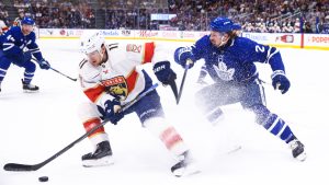 Florida Panthers' Mackie Samoskevich (11) protects the puck from Toronto Maple Leafs' Simon Benoit (2) during first period NHL action in Toronto on Saturday, April 11, 2026. (Cole Burston/CP)