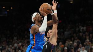 Oklahoma City Thunder guard Shai Gilgeous-Alexander (2) shoots over Phoenix Suns guard Devin Booker during the second half of an NBA basketball game, Sunday, Jan. 4, 2026, in Phoenix. (Rick Scuteri/AP)