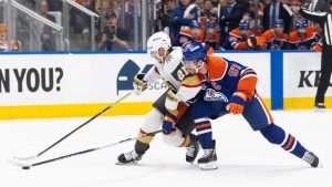 Vegas Golden Knights' Brett Howden (21) and Edmonton Oilers' Connor McDavid (97) battle for the puck during first period NHL action, in Edmonton on Saturday, April 4, 2026. (Jason Franson/CP)