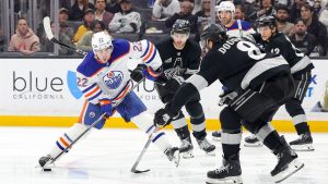 Edmonton Oilers centre Matt Savoie, left, shoots against Los Angeles Kings right wing Alex Laferriere, centre, and defenceman Drew Doughty, front right, during the third period of an NHL hockey game Saturday, April 11, 2026, in Los Angeles. (Ryan Sun/AP)