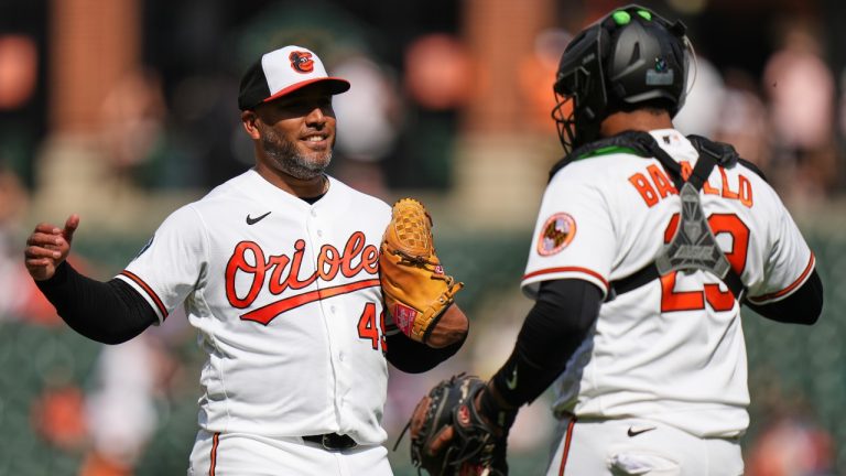 Baltimore Orioles pitcher Albert Suarez, left, and catcher Samuel Basallo, right, celebrate their team's victory over the Texas Rangers after a pitch call was overturned through the Automated Ball-Strike system in the ninth inning of a baseball game, Wednesday, April 1, 2026, in Baltimore. (AP Photo/Stephanie Scarbrough)