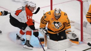 Philadelphia Flyers' Owen Tippett, left, cannot shoot in front of Pittsburgh Penguins goaltender Stuart Skinner, right, during the first period of Game 1 in the first round of the NHL hockey Stanley Cup playoffs in Pittsburgh, Saturday, April 18, 2026. (Gene J. Puskar/AP)