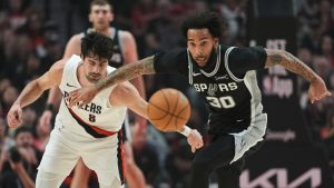 Portland Trail Blazers forward Deni Avdija (8) and San Antonio Spurs forward Julian Champagnie (30) chase a loose ball during the first half in Game 3 of a first-round NBA playoffs basketball series in Portland, Ore, Friday, April 24, 2026. (Jenny Kane/AP)