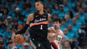 San Antonio Spurs forward Victor Wembanyama (1) drives to the basket against Portland Trail Blazers forward Deni Avdija (8) during the first half in Game 1 of a first-round NBA playoffs basketball series in San Antonio, Sunday, April 19, 2026. (AP Photo/Eric Gay)