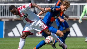 Toronto FC defender Richie Laryea (22) and FC Cincinnati forward Tom Barlow (16) battle for the ball during first half MLS soccer action in Toronto on Saturday, April 11, 2026. (Frank Gunn/CP)