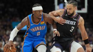 Oklahoma City Thunder guard Shai Gilgeous-Alexander (2) dribbles the ball against Phoenix Suns forward Dillon Brooks (3) during the second half of Game 3 of a first-round NBA playoffs basketball series, Saturday, April 25, 2026, in Phoenix. (AP Photo/Ross D. Franklin)