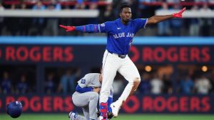 Toronto Blue Jays' Jesus Sanchez (12) slides safely into second base ahead of the tag from Los Angeles Dodgers shortstop Hyeseong Kim (6) during second inning MLB baseball action in Toronto on Tuesday, April 7, 2026. (Nathan Denette/CP)