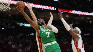 Boston Celtics guard Jaylen Brown (7) goes tot he basket as Miami Heat guard Pelle Larsson, left, and center Bam Adebayo, right, defend during the first half of an NBA basketball game, Wednesday, April 1, 2026, in Miami. (AP Photo/Lynne Sladky)