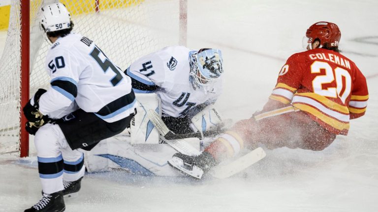 Utah Mammoth goalie Vitek Vanecek, centre, lets in a goal from Calgary Flames' Blake Coleman, right, as Sean Durzi looks on during third period NHL hockey action in Calgary on Sunday, April 12, 2026. THE CANADIAN PRESS/Jeff McIntosh