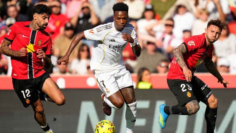 Real Madrid's Vinicius Junior in action betweem Mallorca's Samu Costa, left, and Pablo Maffeo during a La Liga soccer match between Mallorca and Real Madrid in Palma de Mallorca. (Jose Breton/AP)