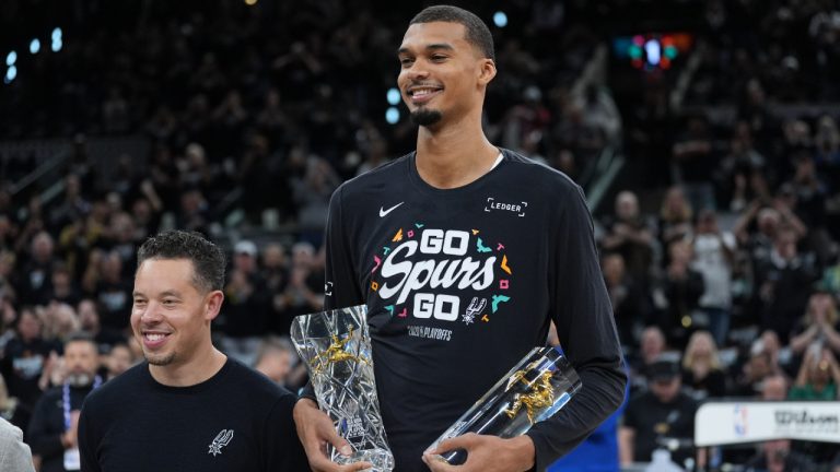 San Antonio Spurs forward Victor Wembanyama, right, stand with head coach Mitch Johnson after receiving his NBA Defensive Player of the Year trophy before Game 2 of a first-round NBA playoffs basketball series in San Antonio, Tuesday, April 21, 2026. (Eric Gay/AP)