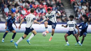 Vancouver Whitecaps' Brian White (24) knocks the ball down out of the air as Emmanuel Sabbi (11), Thomas Muller (13) and Sporting Kansas City's Kwaku Agyabeng (20) and Diego Borges (57) watch during the first half of an MLS soccer match, in Vancouver, on Friday, April 17, 2026. (Darryl Dyck/CP)