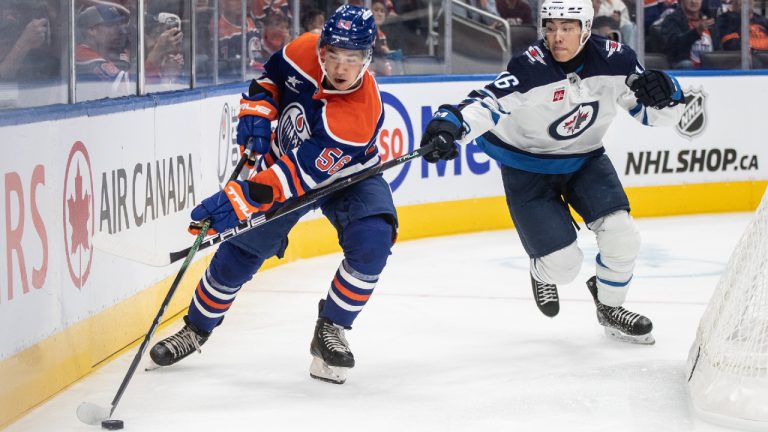 Winnipeg Jets' Kevin He (46) and Edmonton Oilers' William Nicholl (56) battle for the puck during second period NHL pre-season action in Edmonton, Sunday, Sept. 22, 2024. (Jason Franson/CP)
