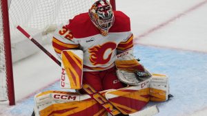 Calgary Flames goaltender Dustin Wolf makes a stick-save in the third period of an NHL game against the Colorado Avalanche, Thursday, April 9, 2026, in Denver. (AP/David Zalubowski)
