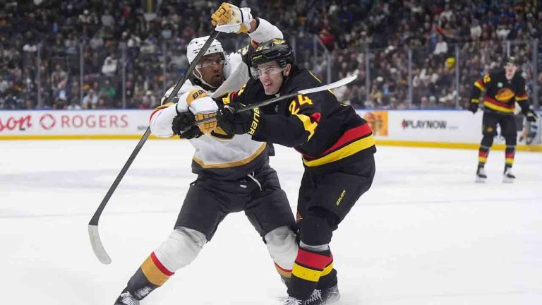 Vegas Golden Knights' Keegan Kolesar, left, grabs Vancouver Canucks' Zeev Buium during the first period of an NHL hockey game, in Vancouver, on Tuesday, April 7, 2026. (Darryl Dyck/CP)