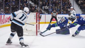 Utah Mammoth's Dylan Guenther (11) scores against Vancouver Canucks goalie Nikita Tolopilo (60) as Marcus Pettersson (29) defends during the second period of an NHL hockey game, in Vancouver, on Saturday, April 4, 2026. (Darryl Dyck/CP)